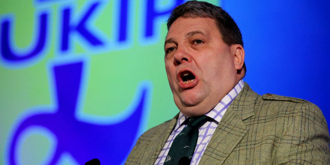 David Coburn in front of a UKIP banner